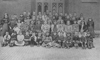 group of boys and girls seated and standing for class portrait