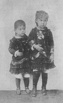 portait of two young children standing with arms linked
