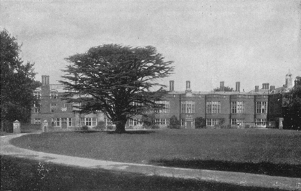 photograph of the hall from a distance, with circular green out front and a single tree.