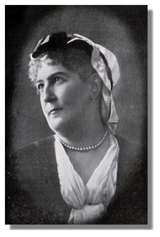 head and shoulders of woman, wearing pearls, looking upward to viewer's left