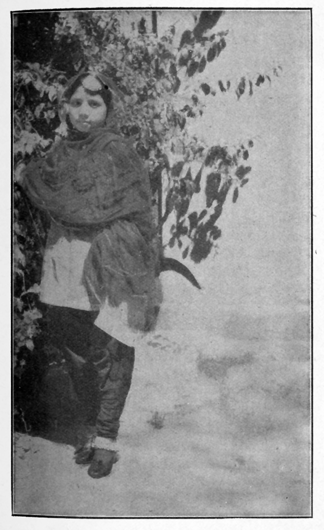 woman standing on the left, plants behind her right