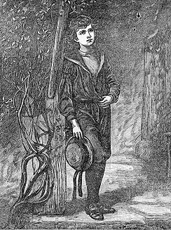 A boy holding a hat leans against a post.