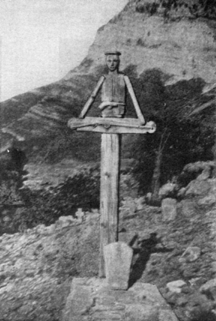 photograph of the cross, it is placed at the head of the grave facing towards it and is made of wood.