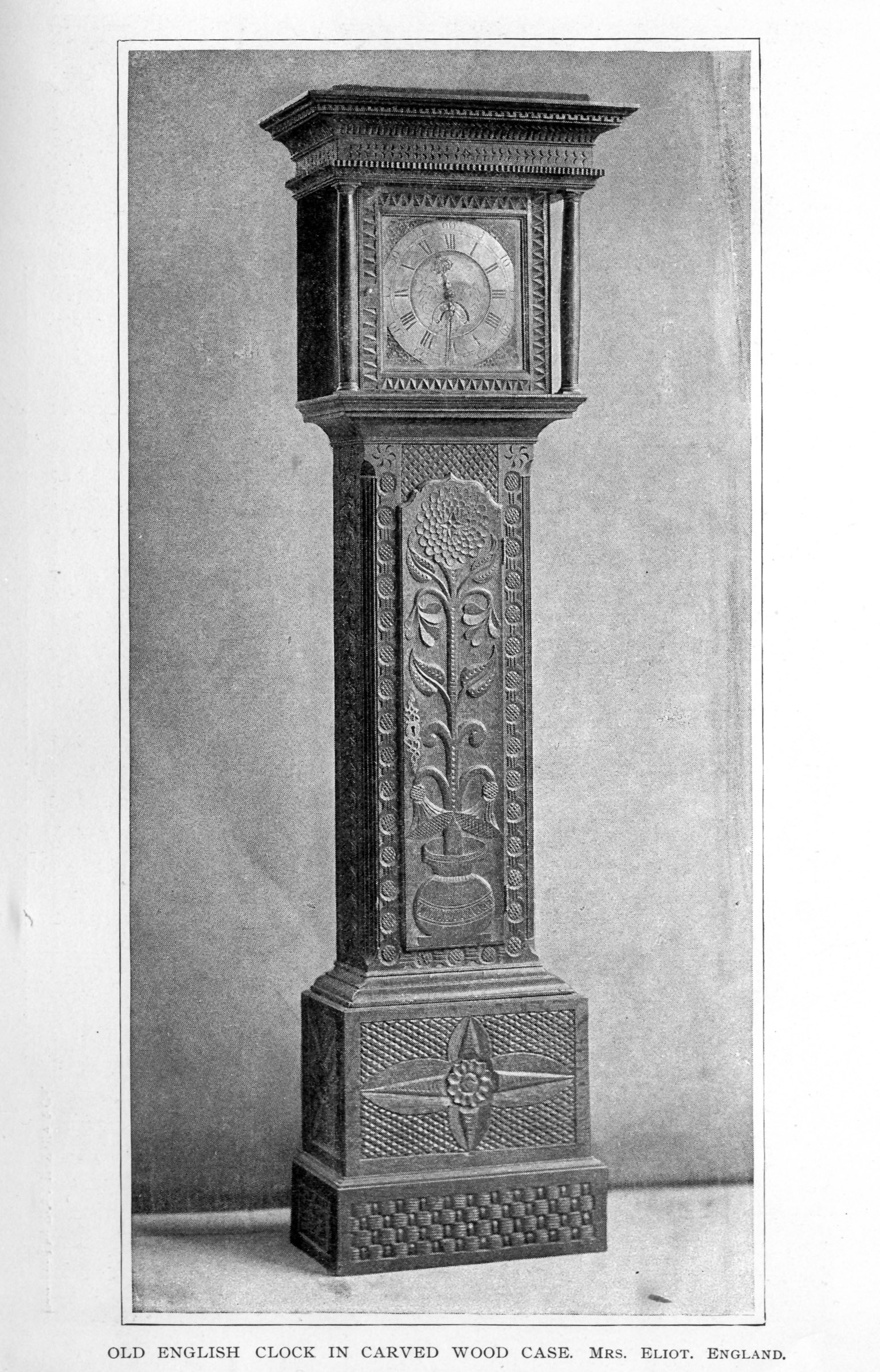 tall wooden grandfather clock, carved with floral decoration