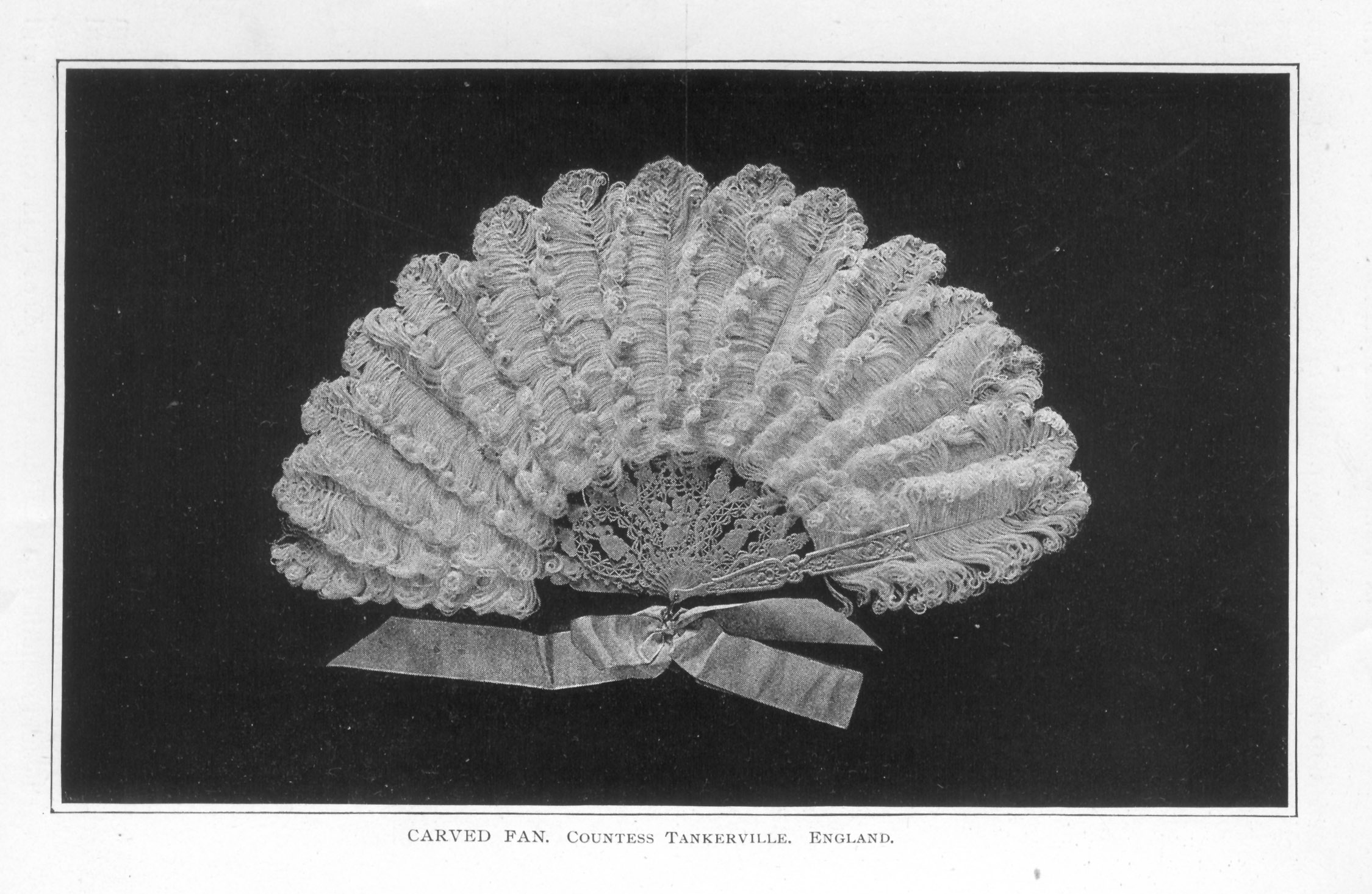 carved fan embellished with feathers and ribbon