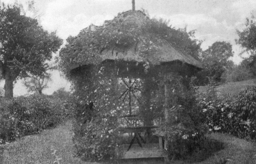 small pointy-roofed gazebo with a table inside.