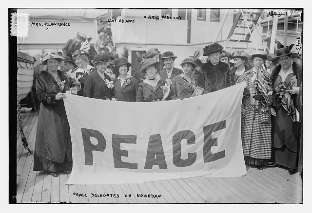 group of women holding banner reading peace