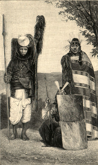 Three men, each in different outfits with different headdresses. Two are standing, one is crouched down half behind a sheild of what looks like wood.