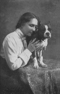 woman holding dog in place on a table and leaning her head toward it