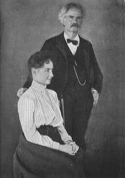 seated woman with man with mustache and bowtie standing
