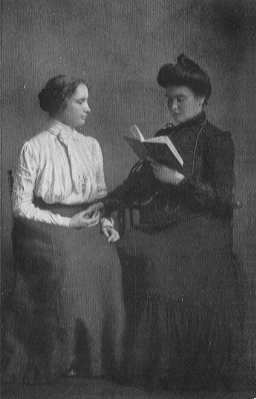 two seated women, one with book