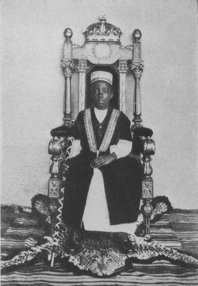 man with staff sitting on throne atop animal-skin rug