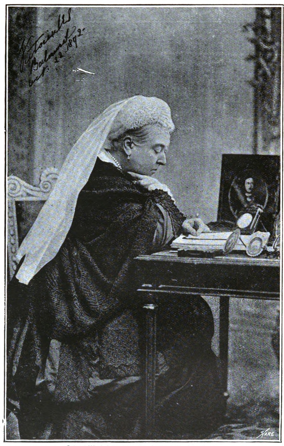 older lady in a flowing cap and veil sitting at a desk
