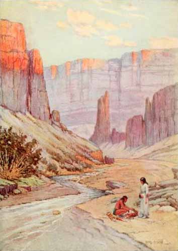 Native American man and woman standing by a river in a canyon.