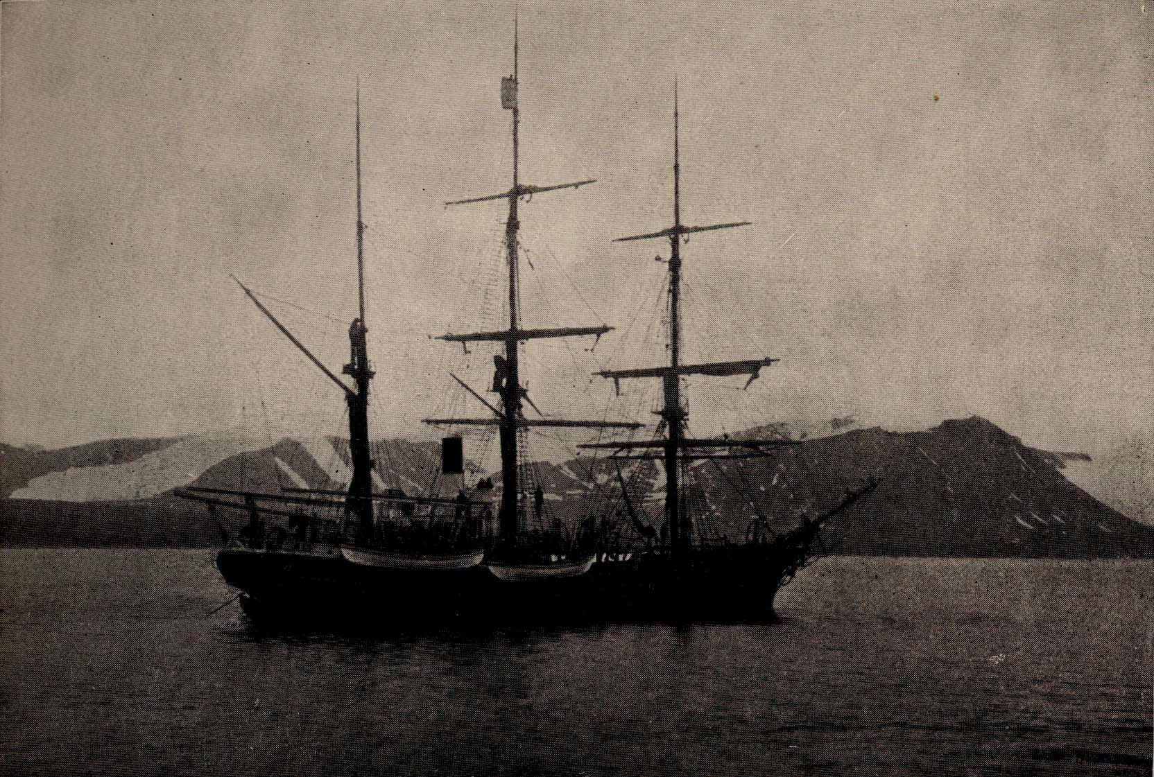 Three masted sailing ship, sails furled.