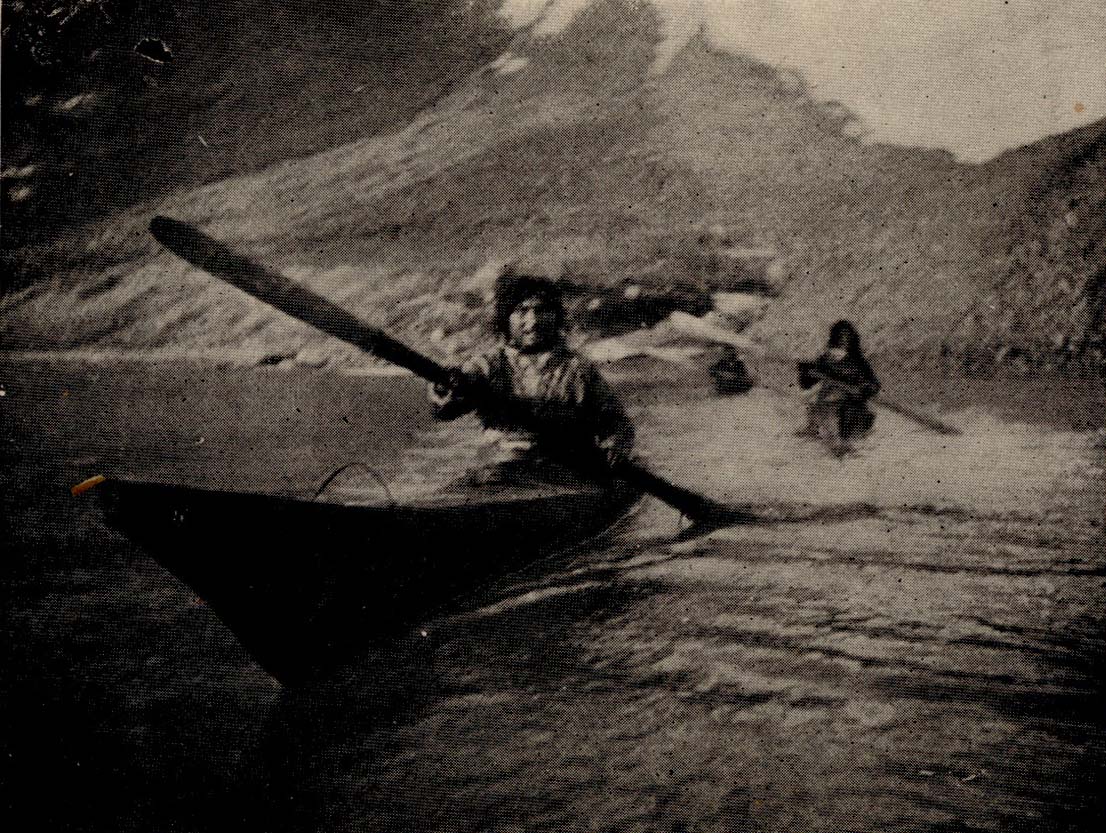 People in Skin Boats paddling across water.