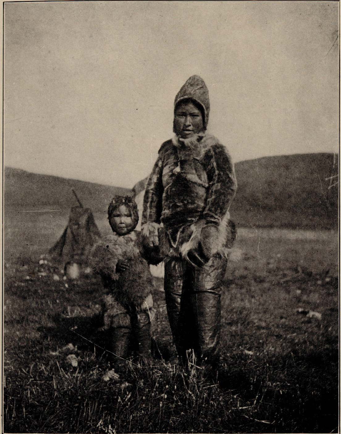 Child and adult woman outside wearing heavy clothing.