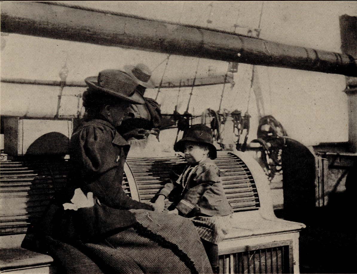 Marie and her mother sitting on a boat in European clothes.