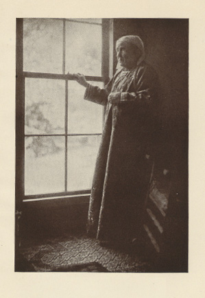 full-length view of older woman standing at a window