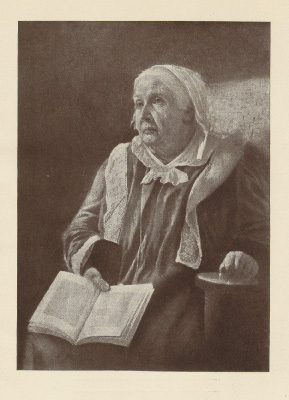 elderly lady seated, holding a book