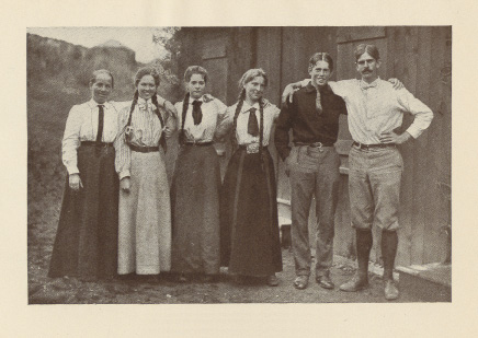 four women and two men standing arm-in-arm
