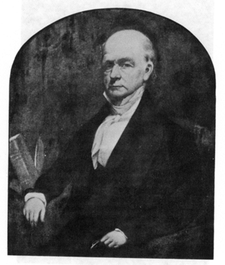 Portrait of a seated bald man in a suit