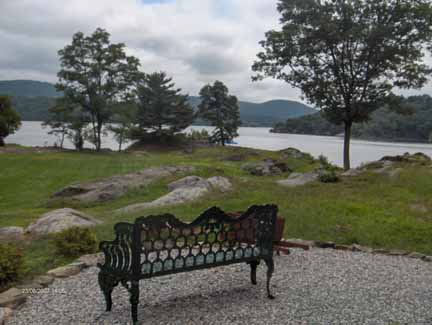 metal bench by lake near mountains