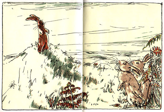 The Velveteen Rabbit sits on a small grassy hill while two real rabbits look at him.