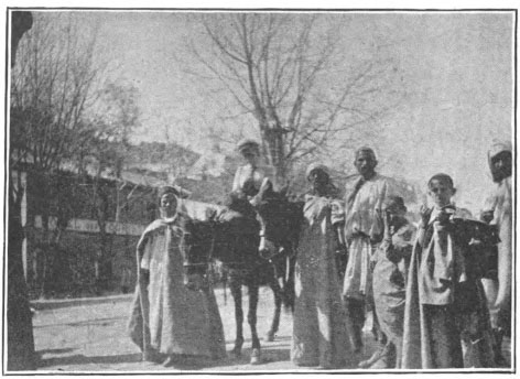 group standing with one person riding a donkey