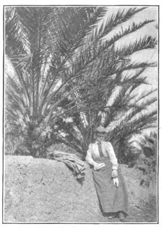 woman standing by palm trees