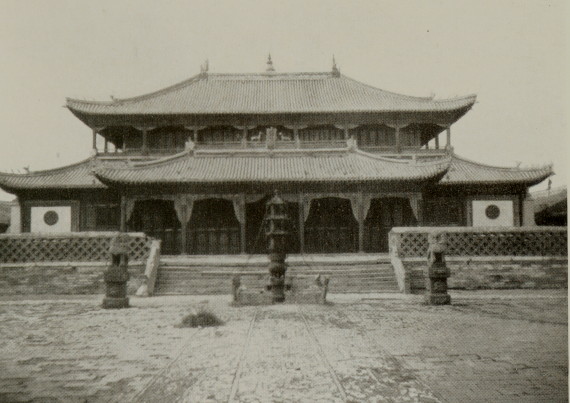 large two-story Asian building with curved sloping roofs and a wide courtyard
