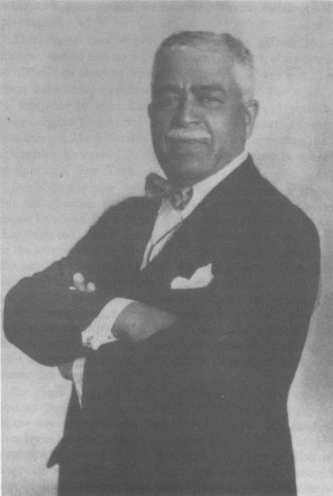 Photograph of Harry T. Burleigh in a suit, standing, arms crossed.