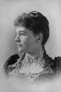 photographic portrait profile bust. her hair is up and she is wearing a dress with a lace collar and high neck