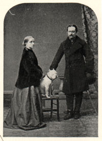 man and woman posing with muscular white dog