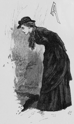 Woman dressed in black hunched over peering onto the ground. A (illuminated letter for Among).