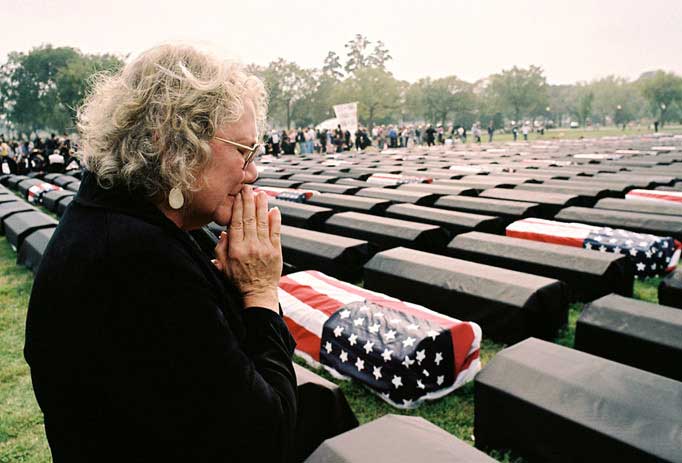 woman looking at field of military coffins