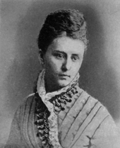 Photograph of woman in dress with elaborate shoulder and neck detailing
