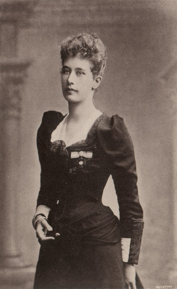 Lovely portrait of Mrs. Grimwood standing in a black dress with puffed sleeves.