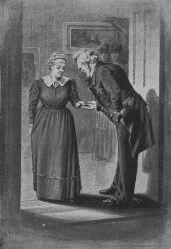 Man greeting a woman by holding her hand and bowing slightly.
