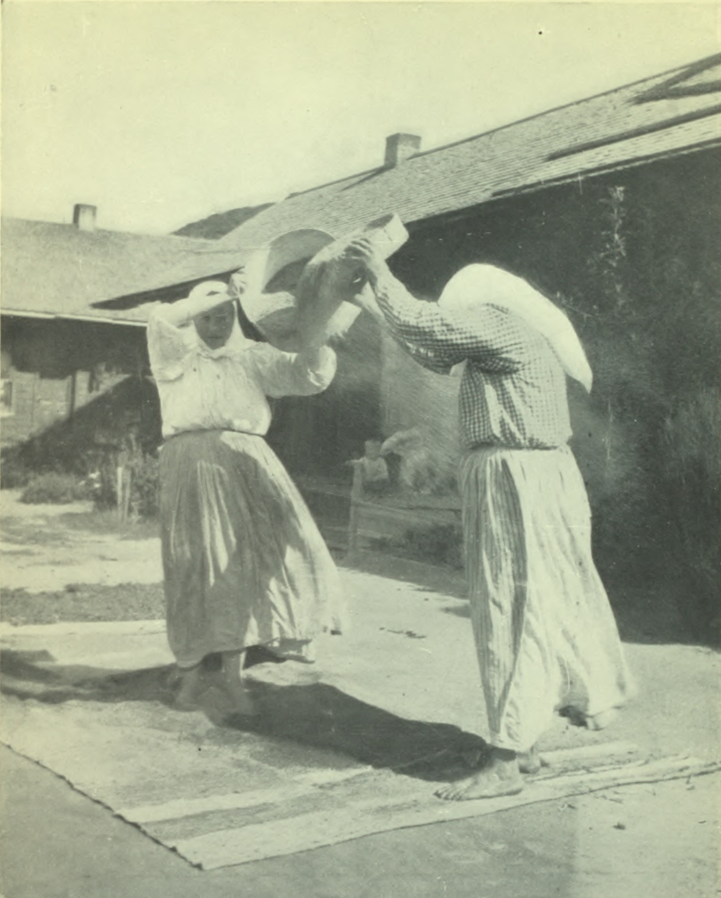 Two women holding up baskets of grain