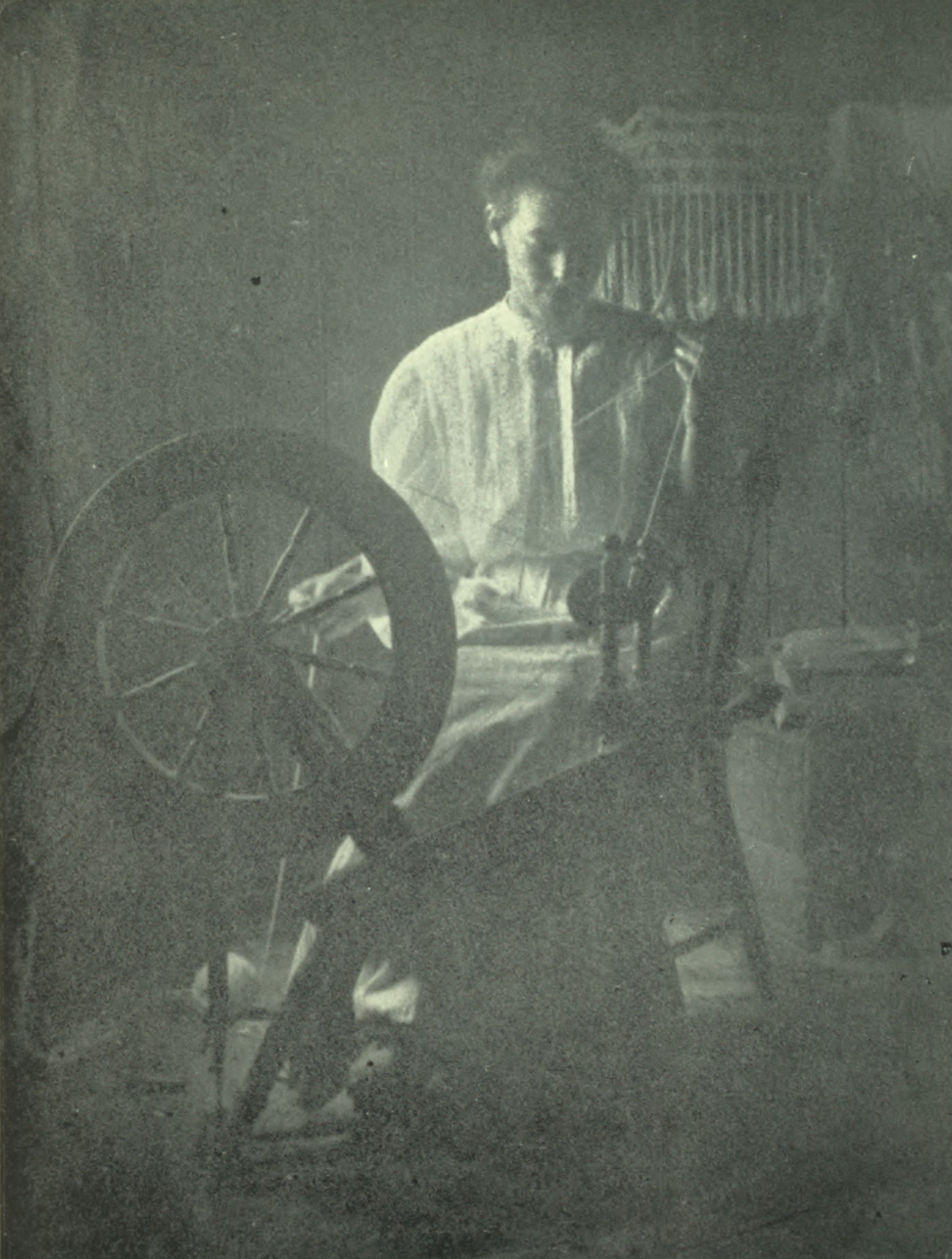 Woman sitting at the spinning wheel.