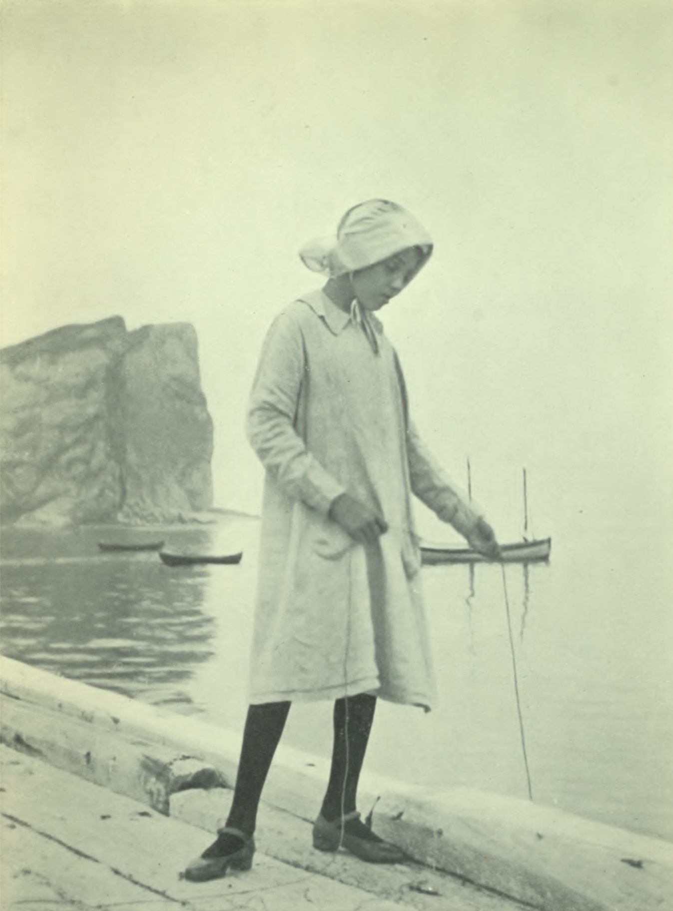 Girl fishing from a wooden platform.