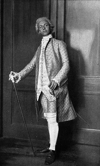 man with powdered hair wearing a brocade suit jacket with matching pants, white stockings, and dress shoes