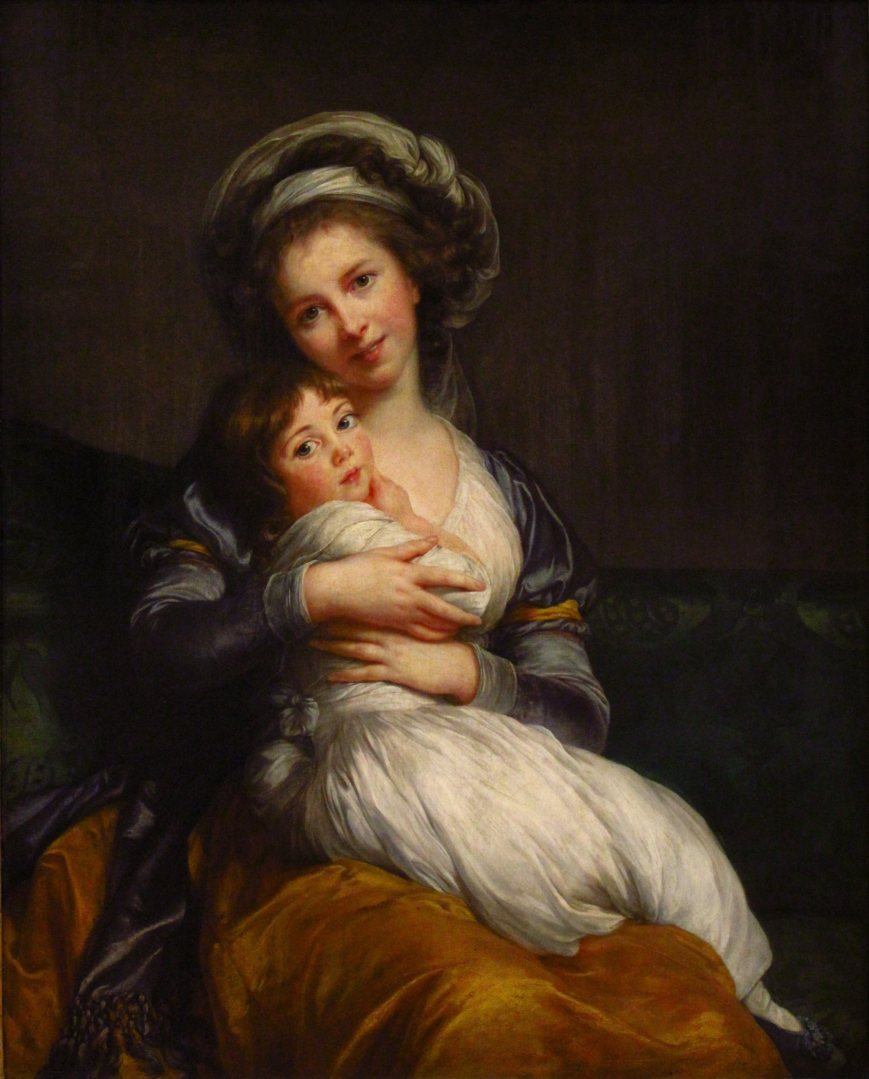 Self portrait of woman holding her young daughter in her lap
