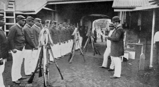 man in bowler hat facing line of men in military uniform