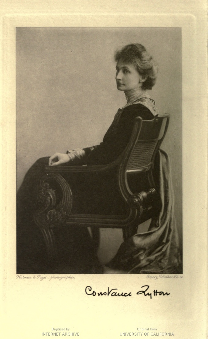 photograph of a woman wearing a long dress, seated in a chair, looking over her left shoulder at the viewer. Signed 'Constance Lytton'.