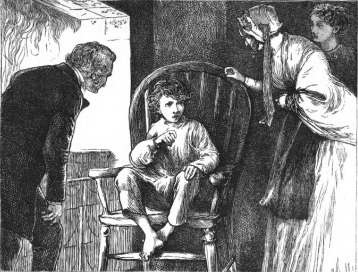 A young boy sitting in a wooden chair. A man and woman stand in front looking at him. A third woman is in background.