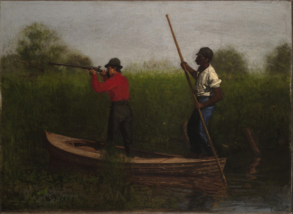 man with gun and man with quant pole standing in small boat