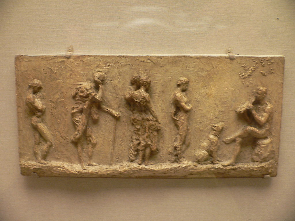 relief sculpture with six people and a dog