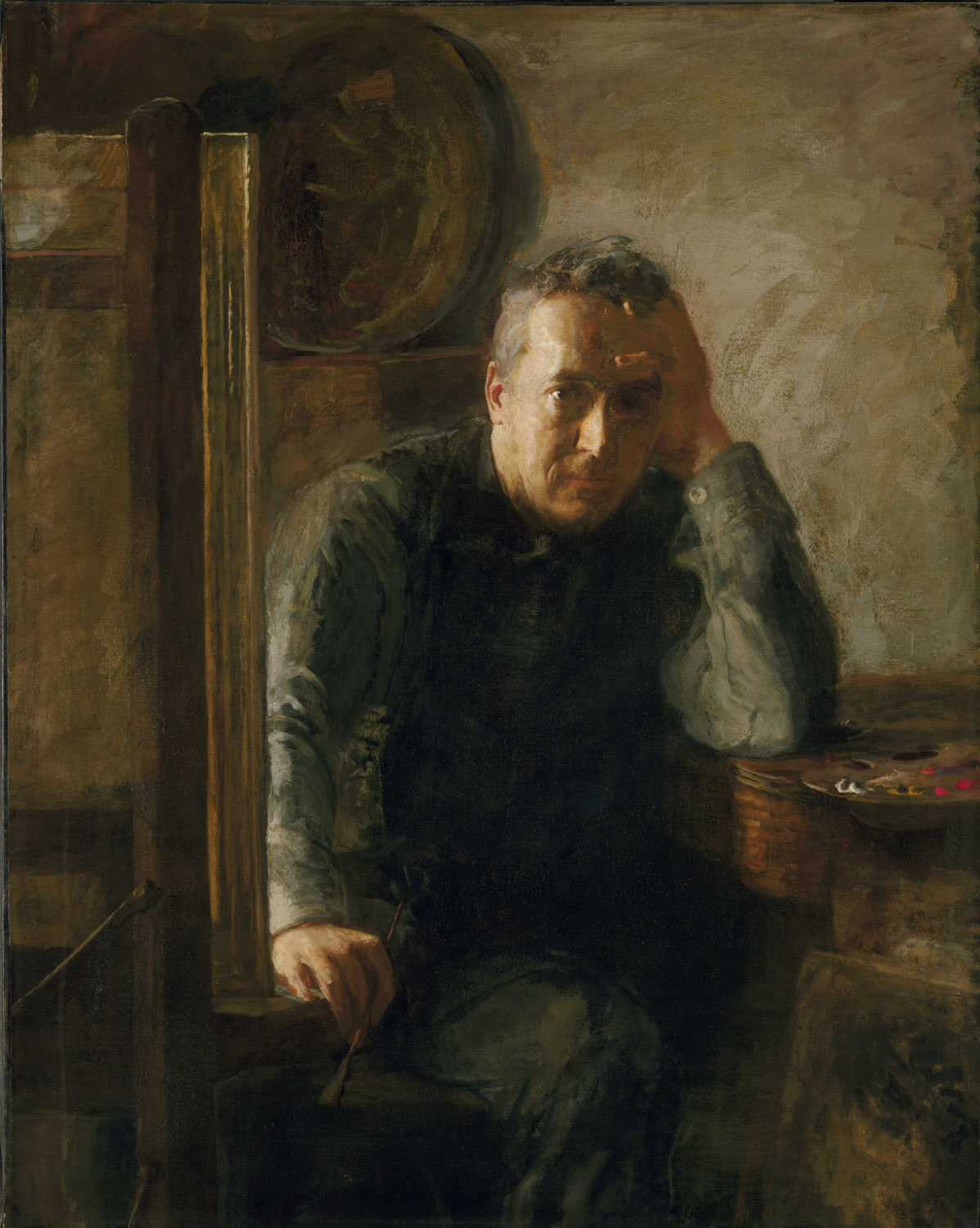 man holding paintbrush sitting at easel